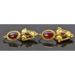 A pair of Roman yellow metal earrings set with garnets