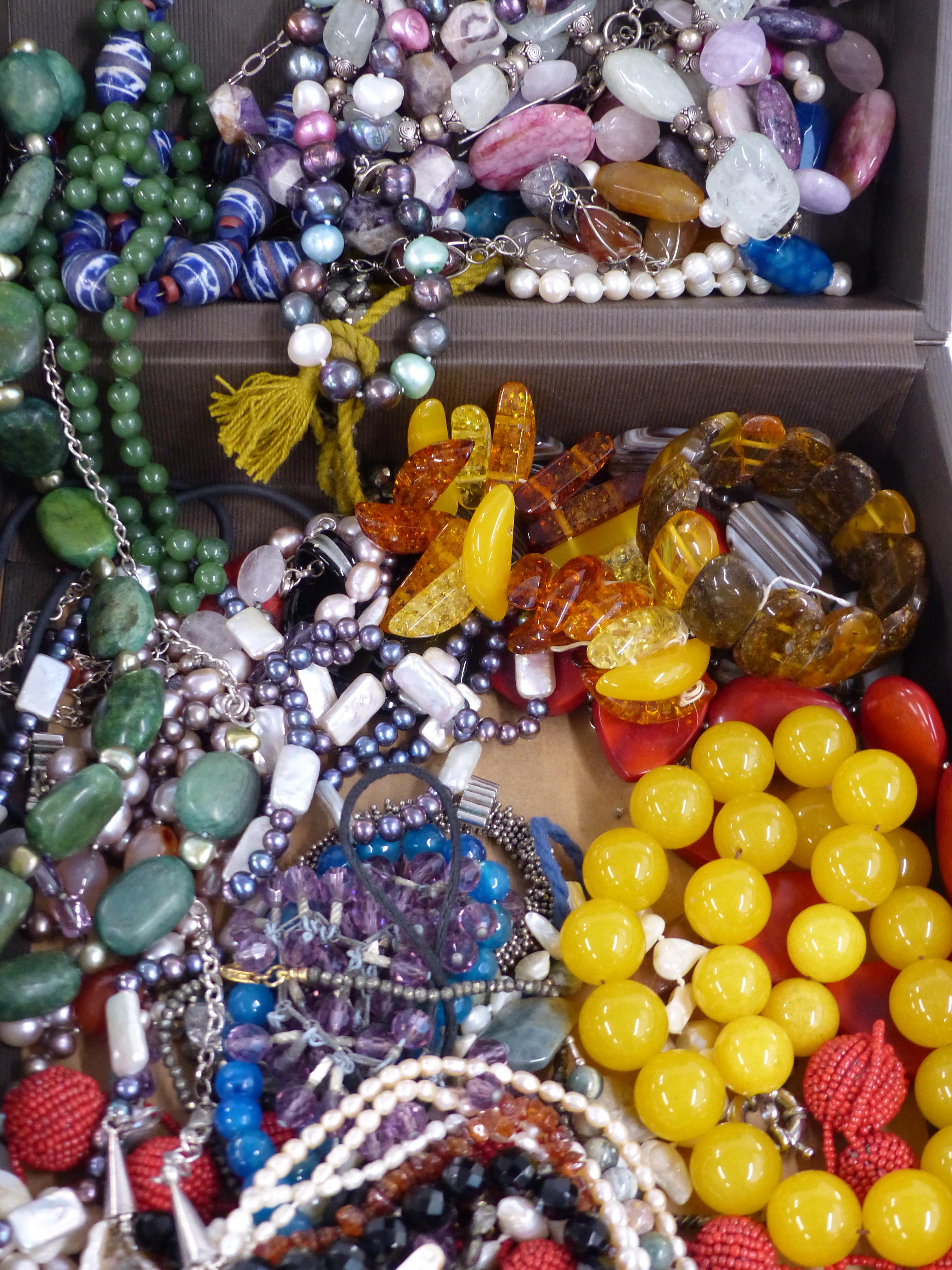 A large collection of beaded necklaces including nephrite jade, pearl, pressed amber, quartz, glass,