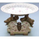 Pierced ceramic centrepiece with brass figural putti supports and masked goat decoration raised on