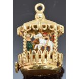 A 14k gold carousel with enamel decoration and a clockwork mechanism, 18.4g