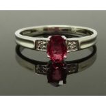 A 9ct white gold ring set with an oval cut synthetic ruby of approximately 0.5ct and diamonds,