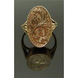 A 9ct gold mourning ring with engraved decoration, the top opening to reveal a glass compartment set