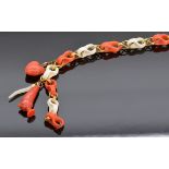 Victorian stick pin made up of alternating coral links, with three charms including heart and mother