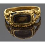 Victorian mourning ring with a central glass compartment and floral decoration to the border and