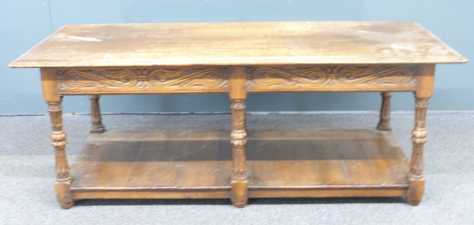 An oak coffee table with carved decoration to the sides and legs, W122 x D54 x H46cm