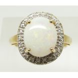 A 9ct gold ring set with an oval opal cabochon and zircon, 3.2g, size N