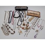 A collection of costume jewellery including brooches, beaded necklaces, Japanese lacquer box etc
