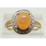 A 9ct gold ring set with an oval Indonesian opal cabochon surrounded by white sapphires, 3.1g,