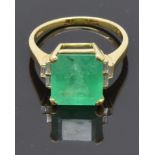An 18ct gold ring set with a natural emerald cut emerald of approximately 5.97ct and three