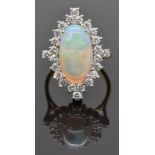 An 18ct gold ring set with a large oval opal cabochon measuring approximately 4ct surrounded by 24