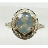 A 9ct gold ring set with an oval cut green fire opal surrounded by diamonds, 3.3g, size N
