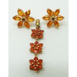 A 9ct gold pendant set with round cut fire opals in three clusters and a pair of 9ct gold earrings