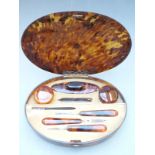 George V ladies faux tortoiseshell dressing set in fitted oval case set with silver gilt hinges,