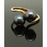 An 18ct gold ring set with two Tahitian black pearls, size O, 3.75g