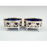 Pair of Victorian hallmarked silver salts with blue glass liners, raised on four feet, London 1900