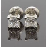 A pair of platinum earrings each set with an emerald cut diamond of approximately 0.4ct, with GIA