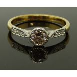 An 18ct gold ring set with a round cut diamond of approximately 0.6ct with diamond encrusted