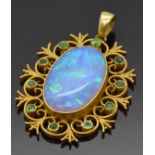 An early 20thC 15ct gold pendant set with a black opal within a scrolling border set with
