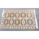 Turkoman rug with geometric design containing ten central guls within a floral border, on beige