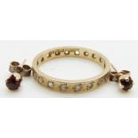 A 9ct gold eternity ring (size N/O) and a pair of 9ct gold earrings set with a garnet to each, 2.8g
