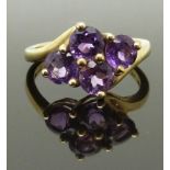 A 9ct gold ring set with four round cut amethysts, size K, 2.63g