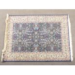 Persian design rug with deep blue ground, arabesque meandering vine pattern and cream border, 175