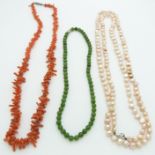 A coral necklace, a pearl necklace, and a nephrite jade necklace