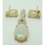 A 9ct gold pendant set with an opal cabochon and zircon and a pair of 9ct gold earrings set with