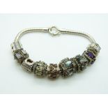 A silver charm bracelet with various charms including topaz, opal, quartz, amethyst, etc