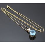 A 9ct gold pendant set with a blue topaz and diamond on 9ct gold chain, 3g