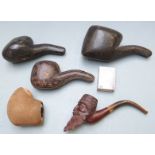 Four cased carved figural Meerschaum pipes including one with armorial or crest, three with amber