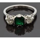 An 18ct white gold ring set with an emerald cut emerald of approximately 0.8ct and two diamonds,
