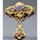 Victorian brooch with scrolling decoration set with large oval cut garnets, 5 x 7.5cm