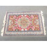 Turkoman rug with geometric design and large central medallion on a red ground within a floral