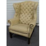Georgian style cream leather or similar wing backed armchair raised on reeded legs.