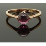 An early 20thC 9ct gold ring set with a garnet cabochon, size P/Q, 1.93g