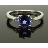 An 18ct white gold ring set with a round cut tanzanite and two round cut diamonds, size K, 2.90g