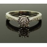 An 18ct gold ring set with diamonds in a cluster and further diamonds to the shoulders, size K/L,