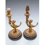 Pair of gilt table lamps formed as putti on a trumpet shaped stem, height 33cm