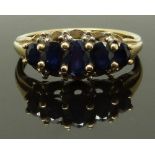 A 9ct gold ring set with five graduated sapphires, size T, 3.36g