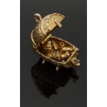A 9ct gold charm depicting a man drunk in a barrel, 5.6g