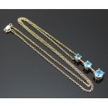A 9ct gold necklace set with three blue topaz, 2.4g