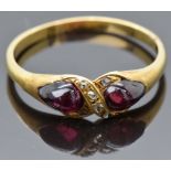 An early Victorian yellow metal ring set with two foiled pear cut garnet cabochons and old cut