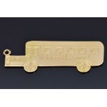 A 9ct gold charm in the form of a bus related to the film 'The Journey' reading "What a Journey,