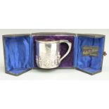 Cased Edward VII hallmarked silver tankard with embossed decoration of figures and landscape,