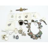 A silver charm bracelet with enamel charms, two silver rings, etc