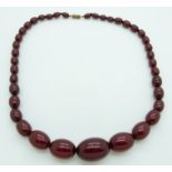 A graduated cherry amber necklace made up of 39 beads, largest bead 21mm x 30mm, 56g