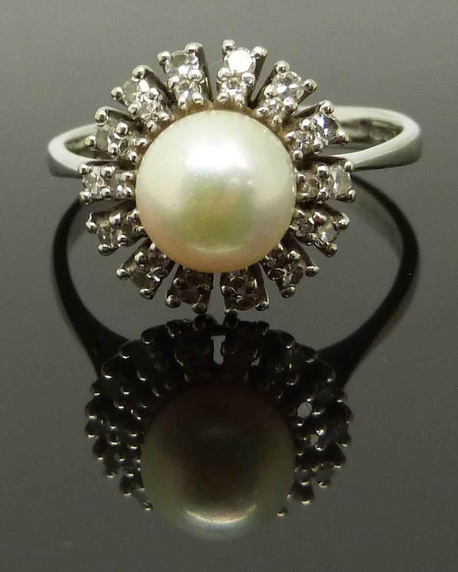 An 18ct white gold ring set with a pearl surrounded by diamonds, size R, 4.89g