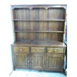 An oak three drawer dresser with plate rack above, W149 x D49 x H190cm