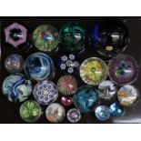 Twenty-one various glass paperweights including Caithness, Isle of Wight iridescent and footed